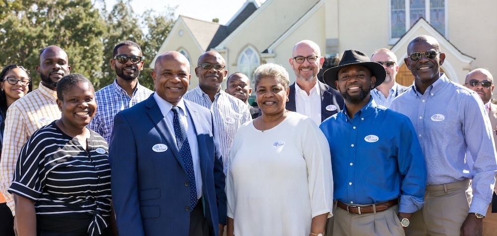 Pastors, church leaders, and members gathered outside their sanctuary with I Voted stickers